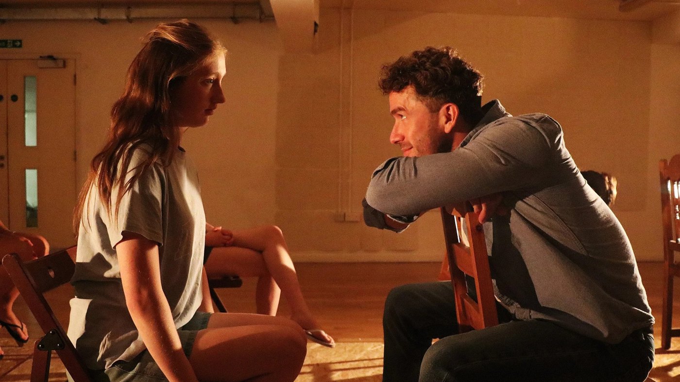 Two GFCA actors rehearsing a scene in warm studio light
